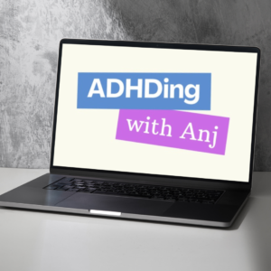 A black laptop computer sitting on a desk with the ADHDing with Anj logo on the screen in blue and purple with a cream background.