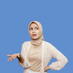 Young muslim woman in beige top and matching head covering with white cardigan on top. She is holding out her hand wondering why she forget her dentist appointment. 